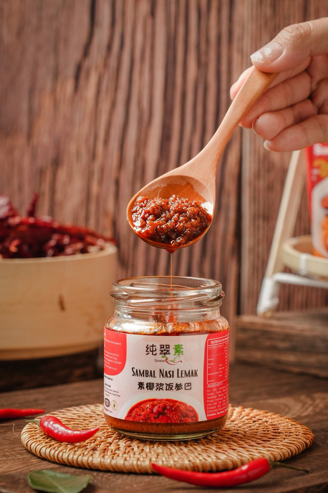 Rich red vegan sambal on a wooden spoon